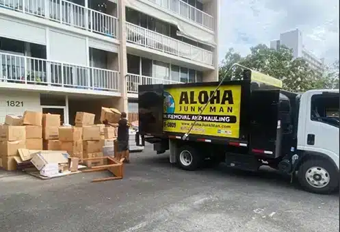 Aloha Junk Man crew removing a large item from a furnished hotel room